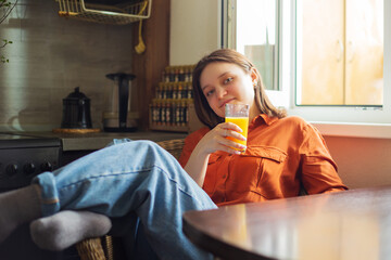Portrait of a pretty woman with a glass of orange juice. - 791838824