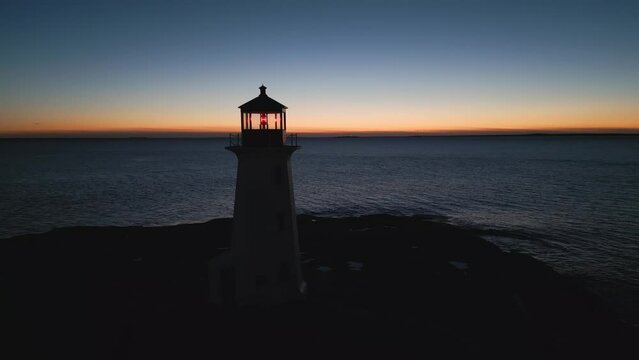 Aerial View Peggy's Cove Lighthouse At Dusk Atlantic Coast Halifax Nova Scotia Canada. Immerse Yourself In Serene Beauty Of The Twilight Hour With Our Captivating Aerial Footage, Lighthouse Silhouette