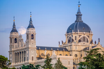 Obraz premium Sunset image of the Almudena Cathedral in Madrid with the full moon in the background