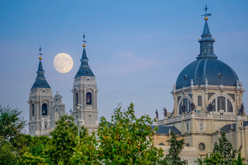 Sunset image of the Almudena Cathedral in Madrid with the full moon in the background
