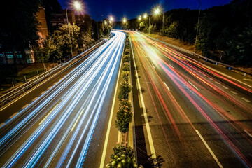 Traces of vehicle lights driving on a highway illuminated by streetlights