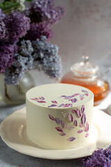 Beautiful spring cake on the background of a bouquet with lilacs. 