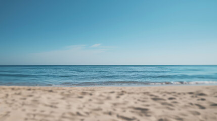 Fototapeta na wymiar Simple, blurry background of a sandy beach and calm sea.