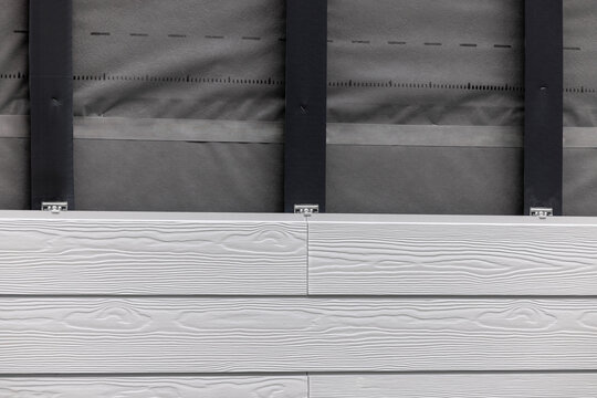 wood texture composite cladding installation on house facade. WPC exterior wall siding panels