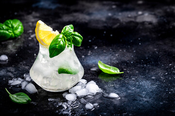 Summer icy cocktail drink with mezcal, liqueur, sugar syrup, lemon, juice, green basil, spices and crushed ice, dark bar counter background - 791860402