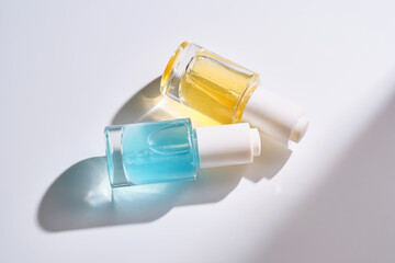 Yellow and blue serums with pipettes against the background of the sun.