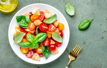 Simple summer salad with with stale bread, cherry tomatoes, olive oil, sea salt and green basil, stone table background, top view - 791862026