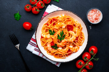 Cooked spaghetti pasta with big shrimp and tomato sauce, black table background, top view - 791862034