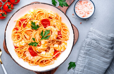Cooked Italian spaghetti pasta with shrimp and tomato sauce, gray table background, top view - 791862236