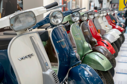 Numerous and colorful Vespas are lined up on display at the Piaggio museum in Pontedera, Pisa, Italy