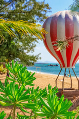 View of the shore of the South China Sea with a sandy beach, palm trees and a hot air balloon, Sanya