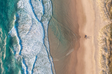 Top view of the ocean beach. Calm seascape with white foam and sand. Travel and leisure concept.
