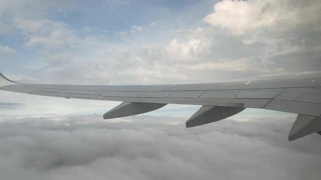 Avion de ligne entre les nuages vue hublot 4K