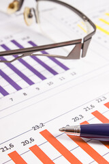 Pen, glasses and financial chart showing production or sales statistics. Business