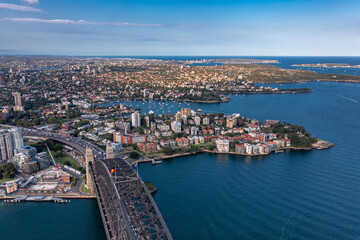 Aerial view along the Sydney Arch Bridge across the Tasman Sea of the city's modern buildings.