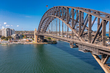 Panoramic view of Sydney Arch Bridge across the Tasman Sea behind the modern buildings of the city.