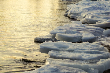 small waves of the Baltic Sea pour over the icy shore in winter