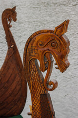 Ornately carved wooden dragon heads on the  bow of a viking vessel.
