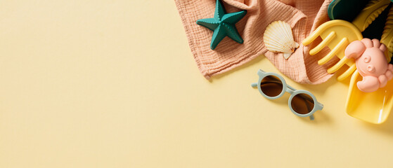 Flat lay composition with children's beach toys, sunglasses, seashells, towel on beige background.