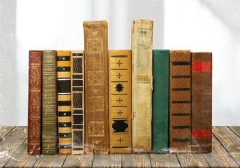 Old books row on desk background