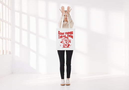 Mockup of woman holding customized tote bag in front of her