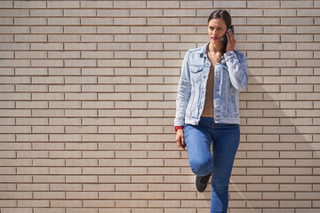 Beautiful woman talking on the phone while on the street