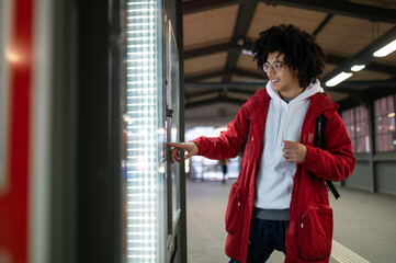 Curly-haired young guy scrutinizing the trains timetable