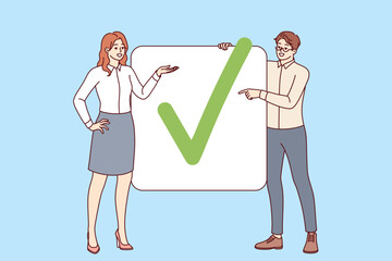 Business partners have completed project show check mark proving completion of assigned tasks. Man and woman office employees striving together to achieve commercial goals and complete project - 791931427