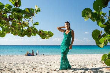 woman in a green evening dress sits on the sand near the Atlantic ocean, Caribbean, Cuba, vacation in Cuba, travel, vacation, retreat