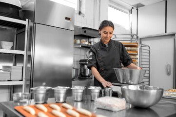 Cute young woman working in a kitchen and looking involved