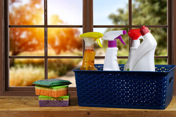 sponges and natural cleaning products in the basket near window showing olives field. Eco-friendly...