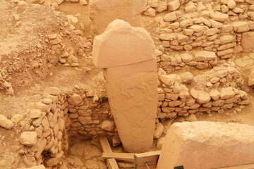 Pillar 2 in Enclosure A at the neolithic archaeological site of Göbekli Tepe, Potbelly Hill, a t-shaped pillar showing an auroch, a fox and a crane, close to Sanliurfa, Turkey