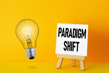 Paradigm Shift is shown using the text and photo of light bulb - obrazy, fototapety, plakaty
