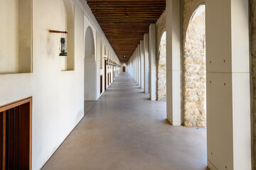 An interior hallway with arches inside the histori Qasr Al Hosn, an 18th century fortress in the downtown district of Abu Dhabi, United Arab Emirates.