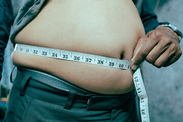 An obese man measuring his belly