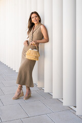 Elegant woman in fashionable dress smiling on minimalist background