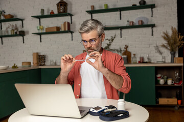 Diabetic man getting online consultation on laptop at home