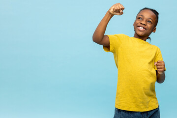 Overjoyed dark- skinned little boy celebrating victory