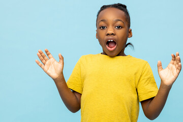 Surprised dark- skinned little boy yelling with raised arms