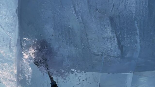 slow motion. a man makes a product out of ice. A man cleans the ice. a man chops off a piece of ice.The guy is making something out of ice. a trip to Lake Baikal