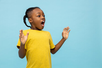 Side view African American little boy screaming something with astonishment