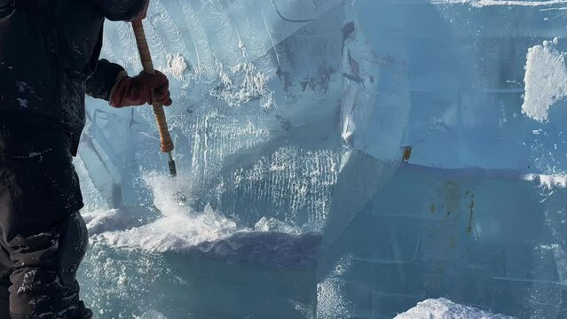 slow motion. a man makes a product out of ice. A man cleans the ice. a man chops off a piece of ice.The guy is making something out of ice. a trip to Lake Baikal