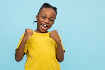 Satisfied African American little boy celebrating his success