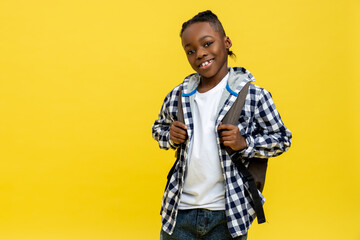 Cute african american schoolboy in checkered tshirt looking happy