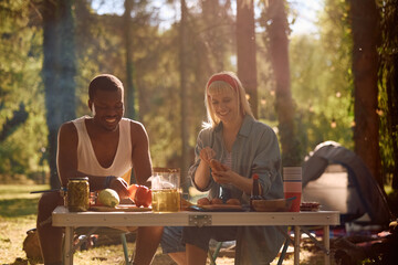 Happy couple having  picnic while camping in nature.