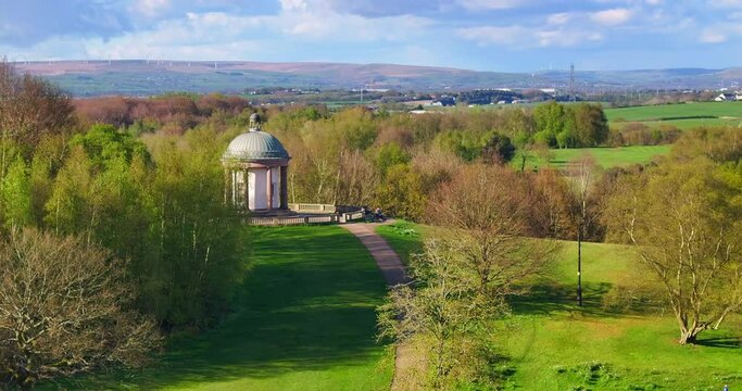 Aerial video of Heaton Park, Greater Manchester UK showing wind turbines on the Horizon