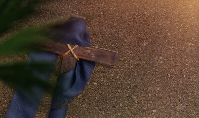 Wooden cross and palm leaf on background