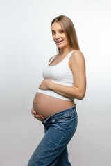 Smiling pregnant woman in jeans and white tshirt