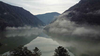 Majestic canyon landscape with a gentle mist over Sil River, framed by towering mountains, perfect...