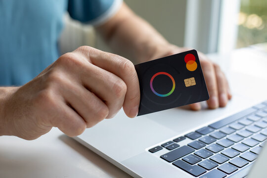 Man hand hold credit card Mastercard under Macbook Pro 16